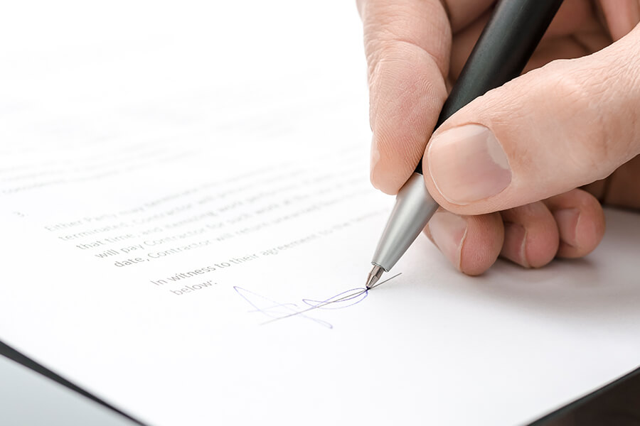 Männliche Hand unterschreibt Vertrag