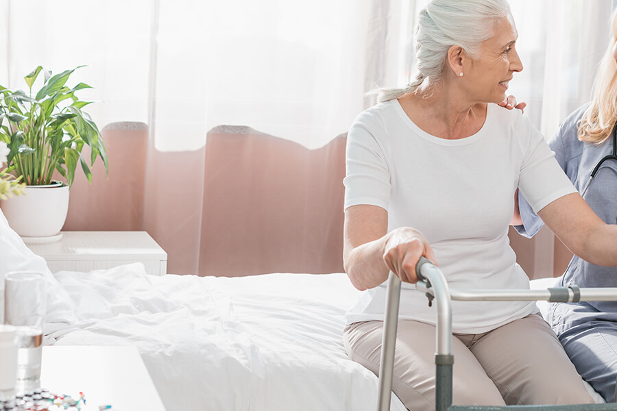 Closeup frau mit rollator und Pflegekraft